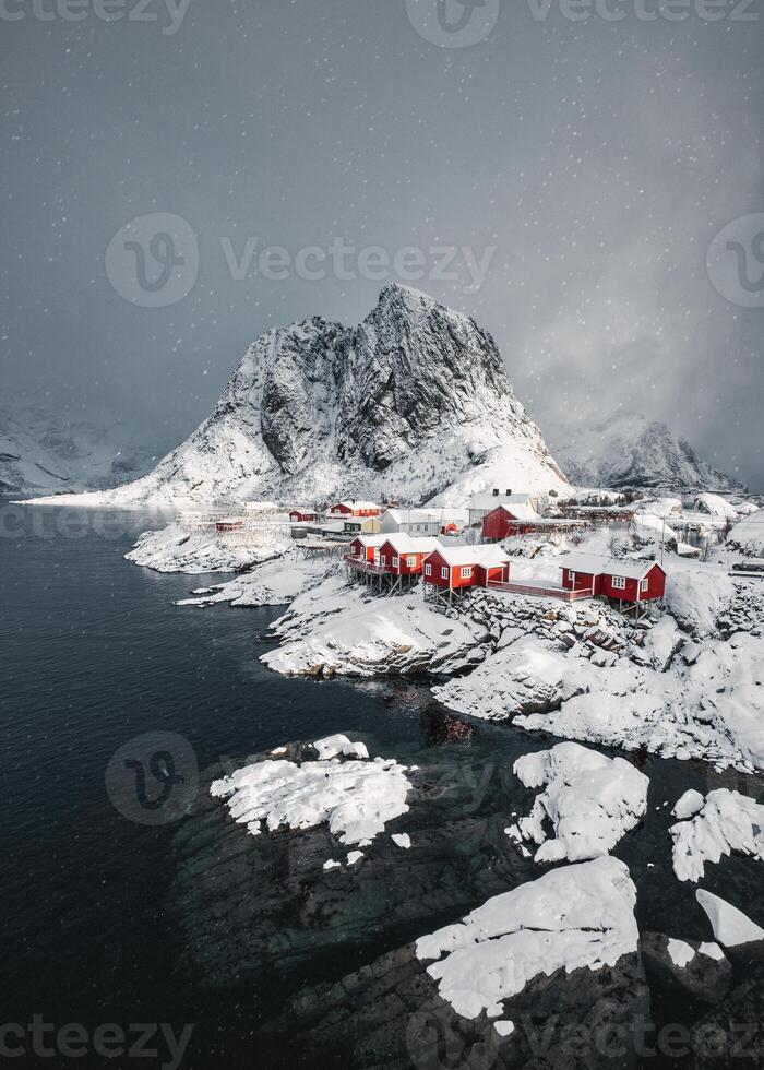 Snowing in Hamnoy fishing village with snowy mountain on coastline at Lofoten Islands photo