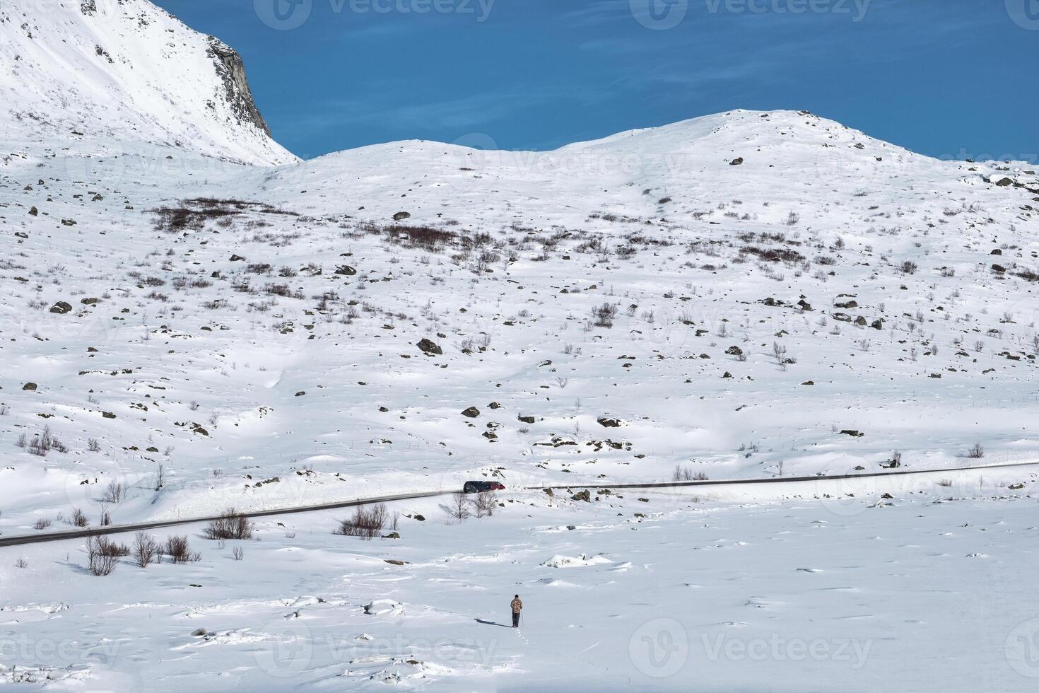 Nevado montaña rango y el la carretera en invierno en soleado día a lofoten islas foto