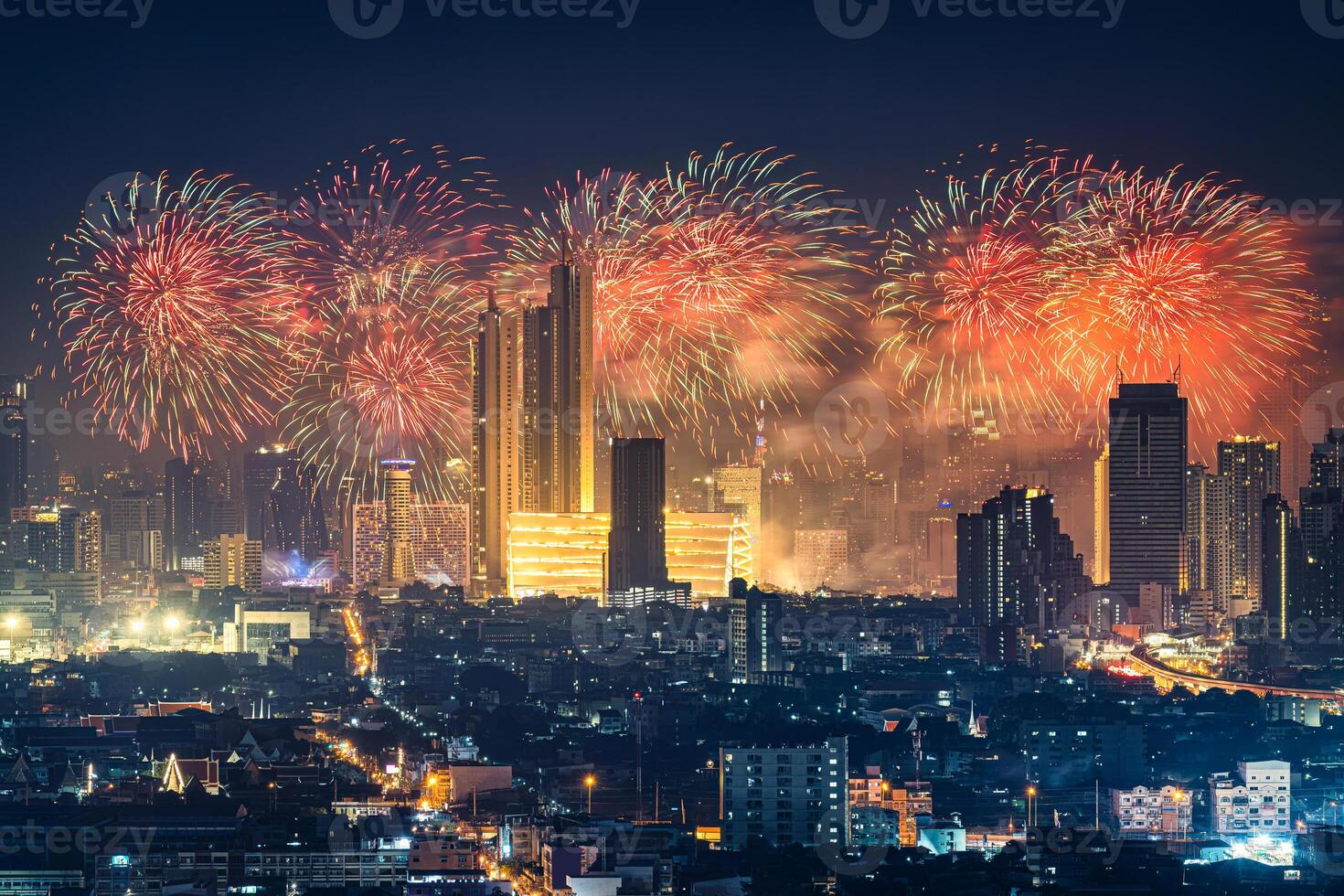 New year festival with firework display glowing over department store, illuminated building in downtown during midnight time at Bangkok, Thailand photo