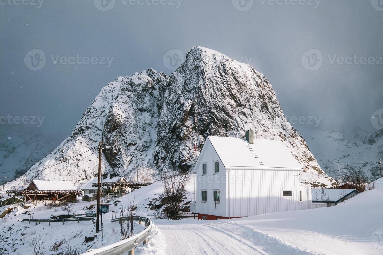 White house with cod fish industry and snow mountain in snowing day at Lofoten islands photo