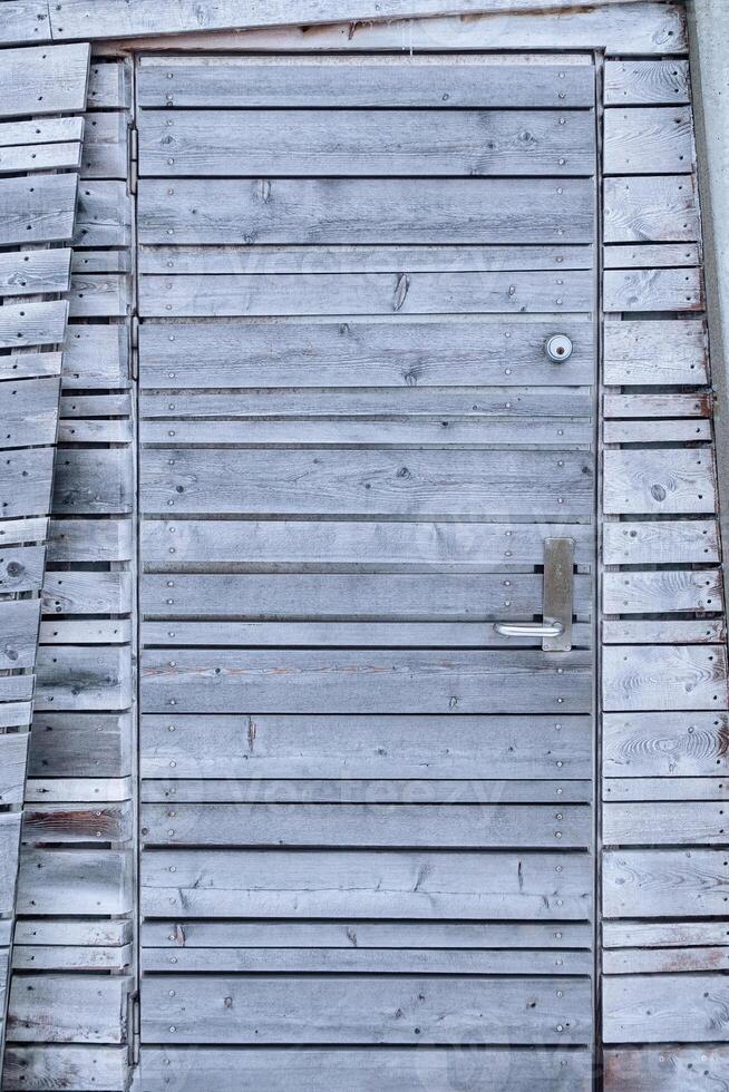 Envejecido de madera gris puerta de el cabaña en travesía foto