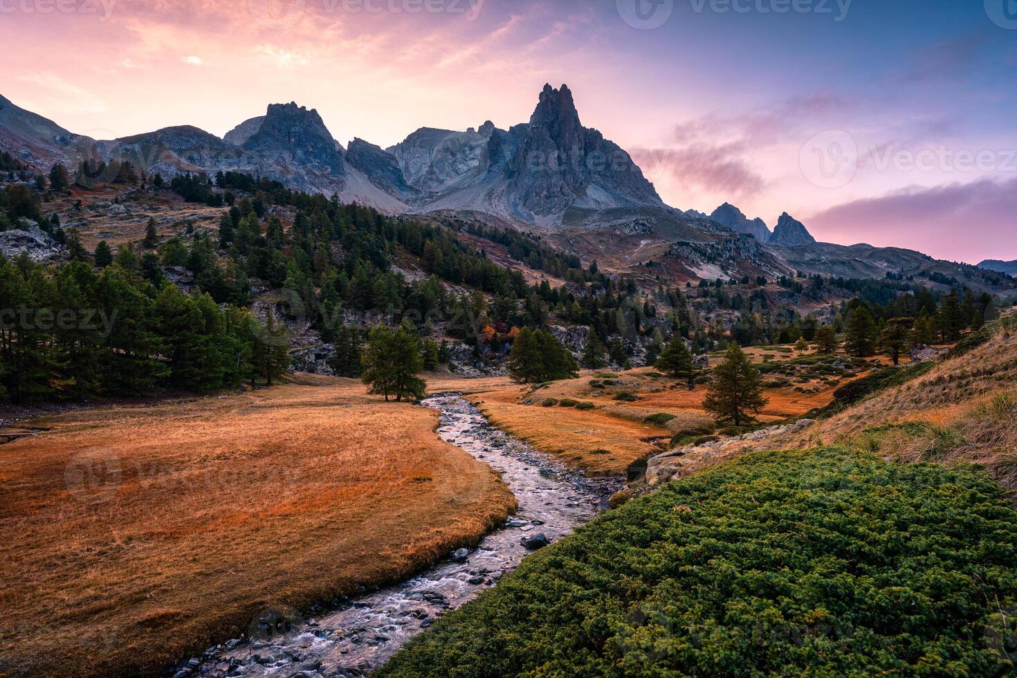 Sunset over Claree Valley with Main De Crepin peak and river flow through in larch forest during autumn at French Alps, France photo