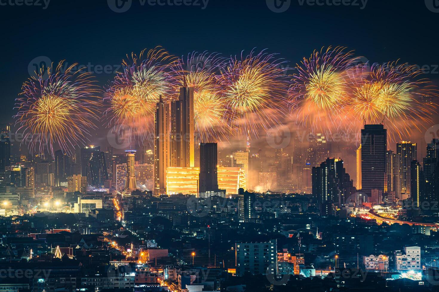 New year festival with firework display glowing over department store, illuminated building in downtown during midnight time at Bangkok, Thailand photo