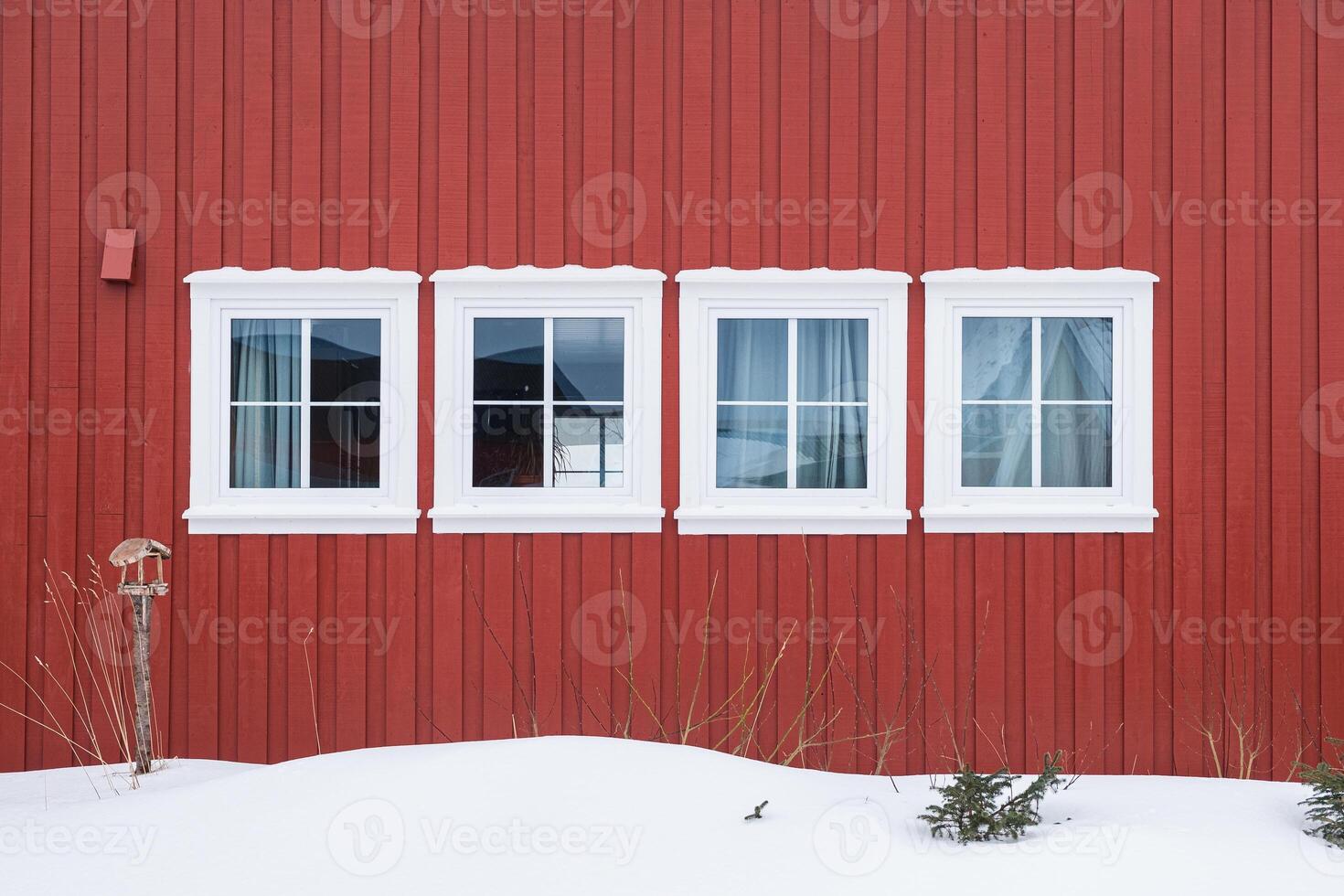 Row white windows with wooden red wall and snow photo