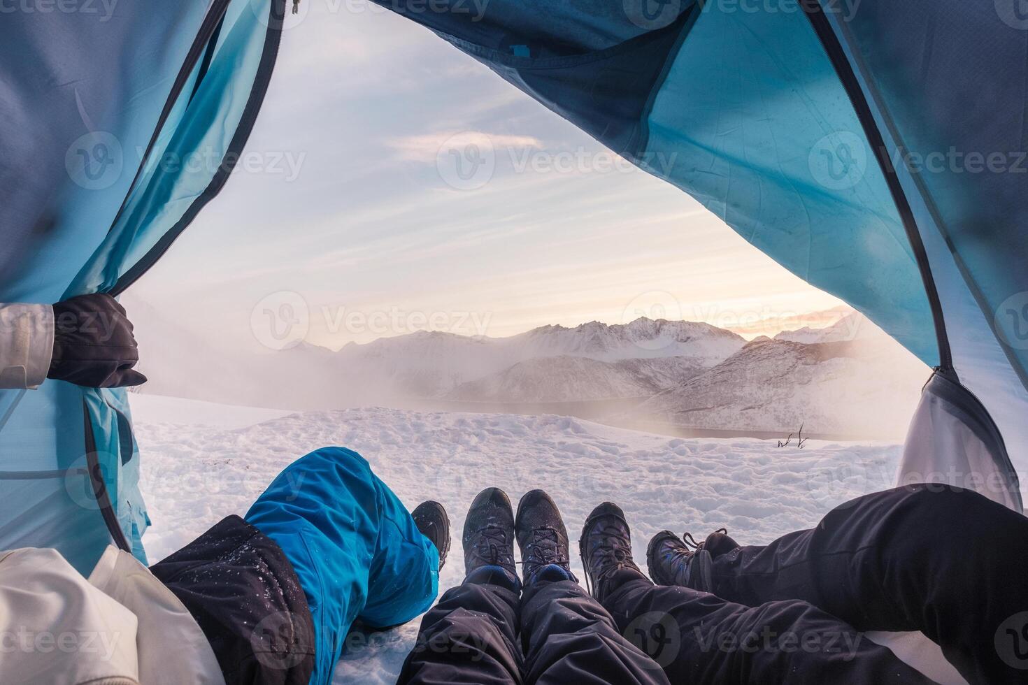 Group of climber are inside a tent with open for view of blizzard on mountain photo