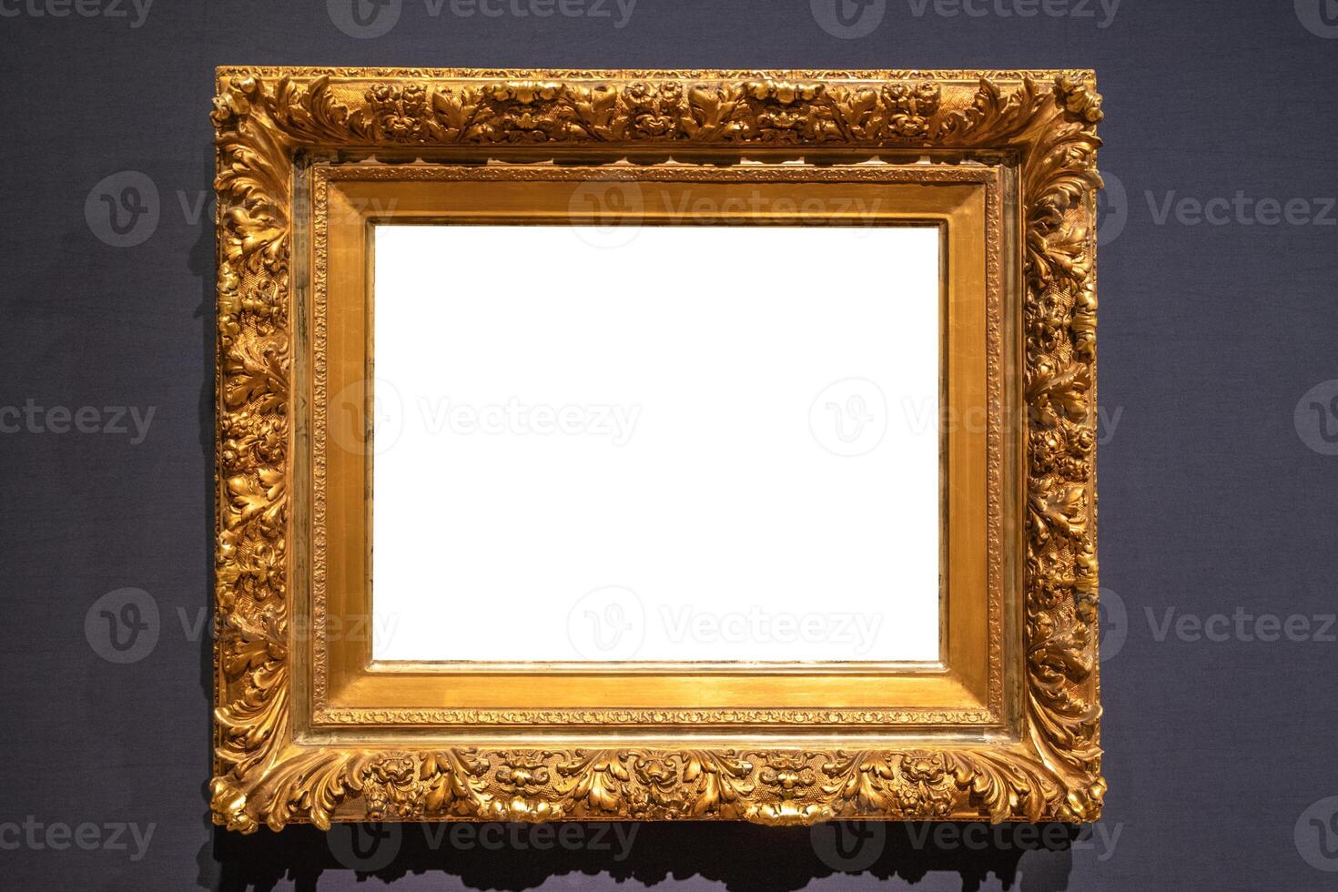 Antique golden carved picture frame on wall photo