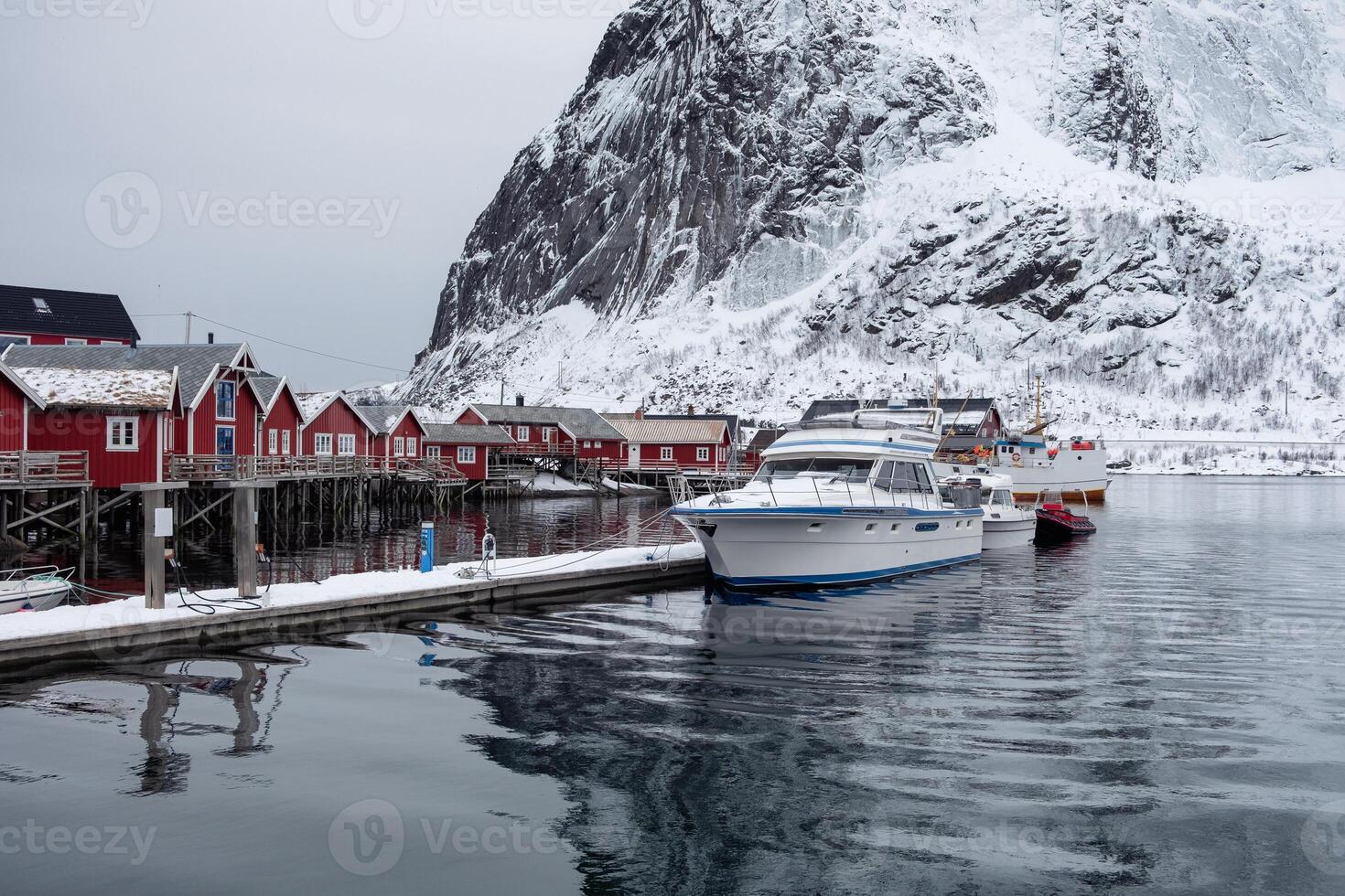 Boat anchored on pier with fishing village in Lofoten photo