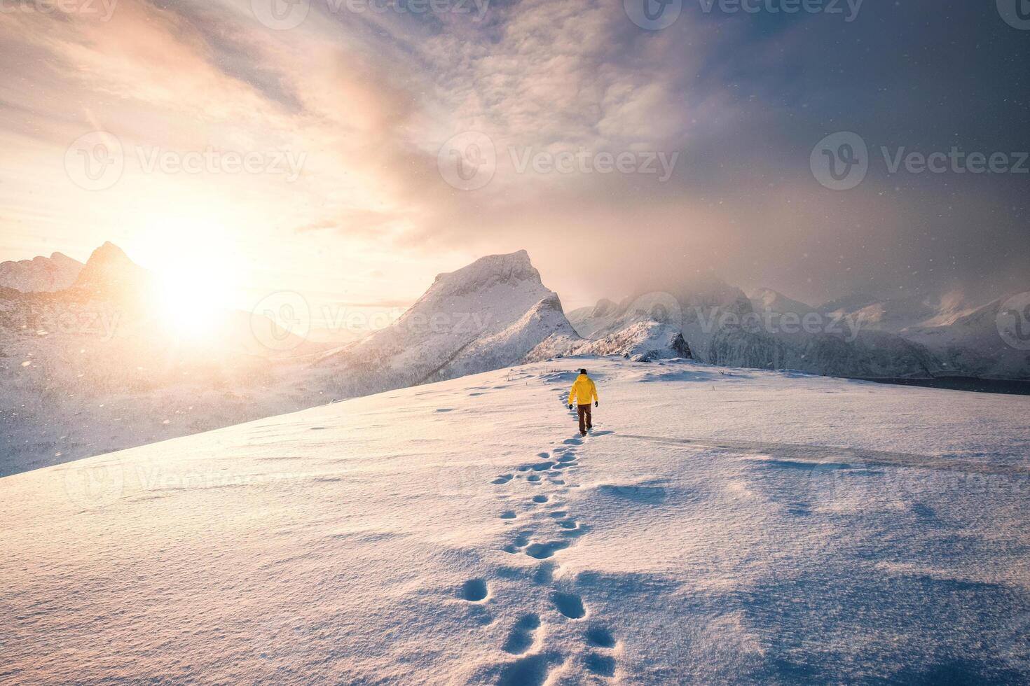 alpinista caminando con huella en nieve tormenta y amanecer terminado Nevado montaña en senja isla foto