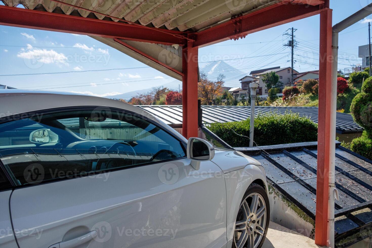 blanco moderno deporte coche estacionado dentro abierto garaje y ver fuji-san montaña foto