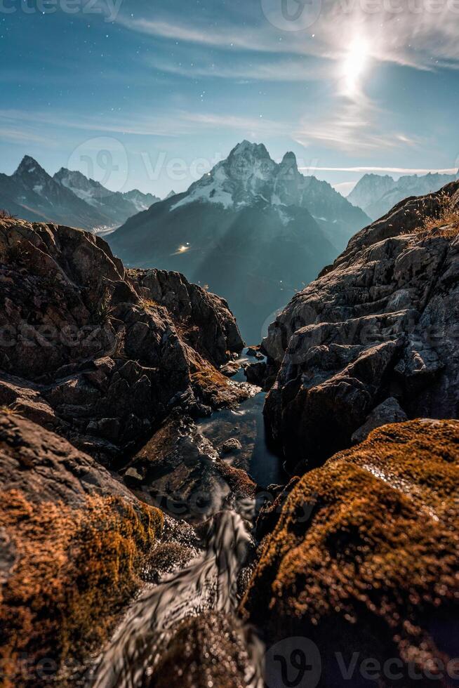 Mont Blanc massif with rock mountain and moonlight in night sky at Lac Blanc, France photo