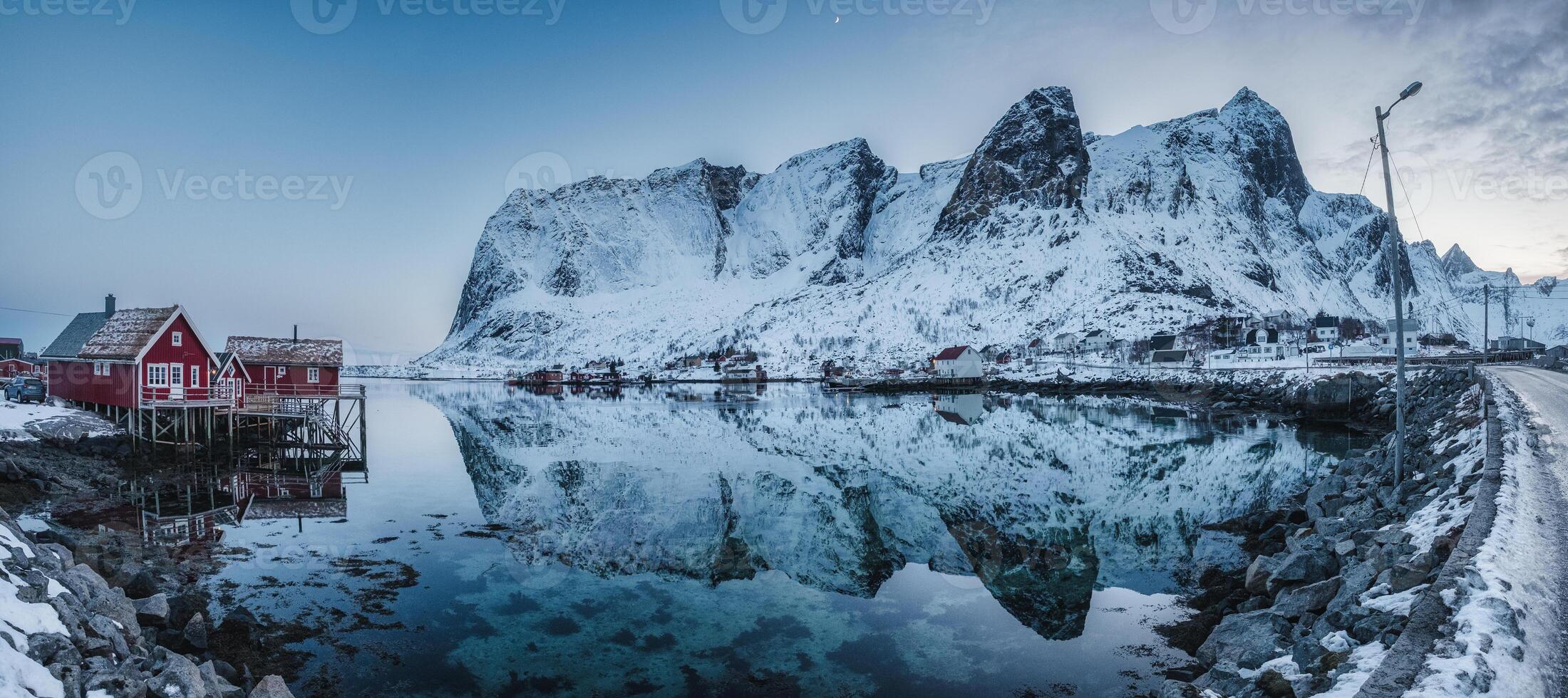 Panorama of Fishing village on coastline and snowy mountain range in winter on gloomy day at Lofoten Islands photo