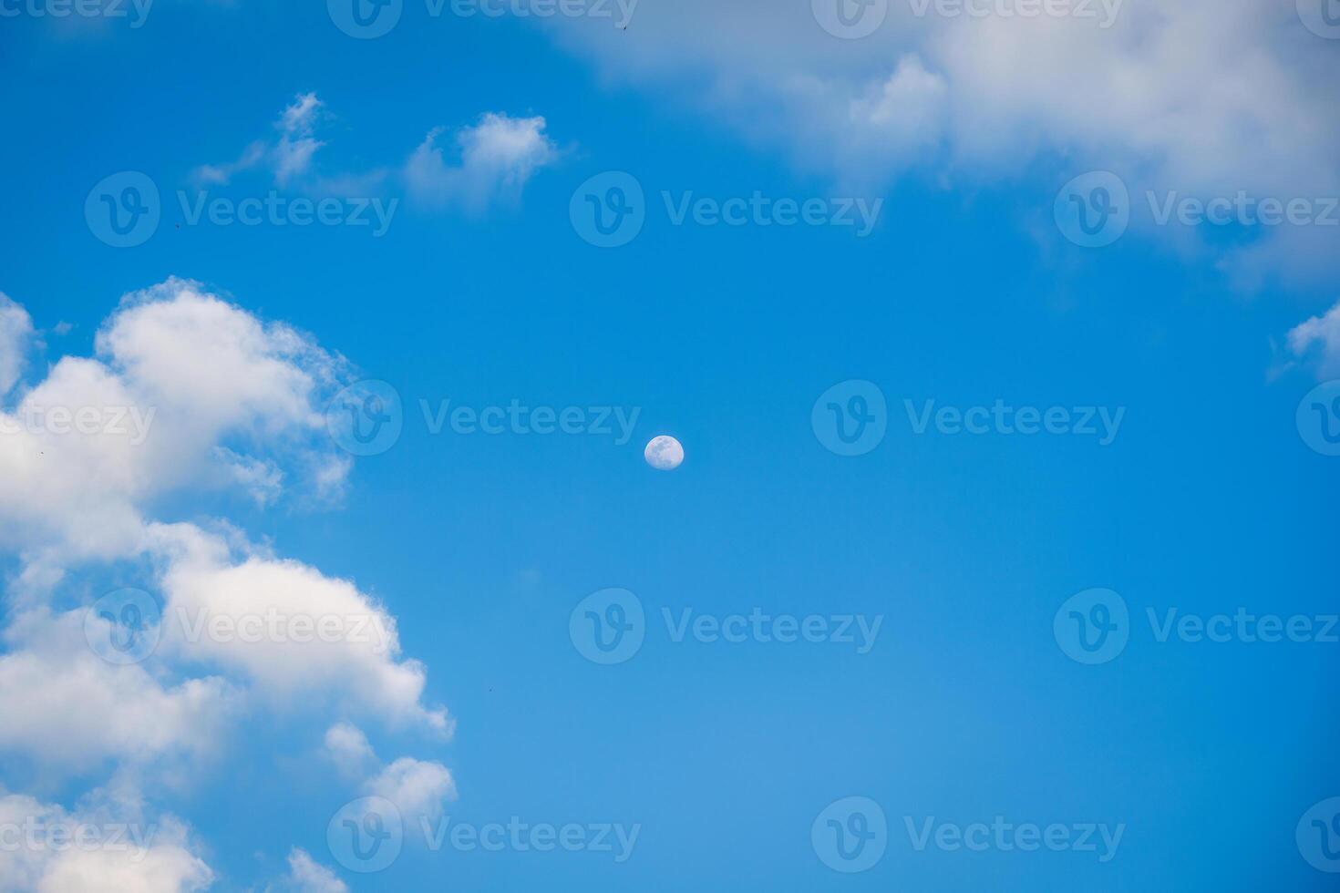 Moon with clouds in blue sky photo