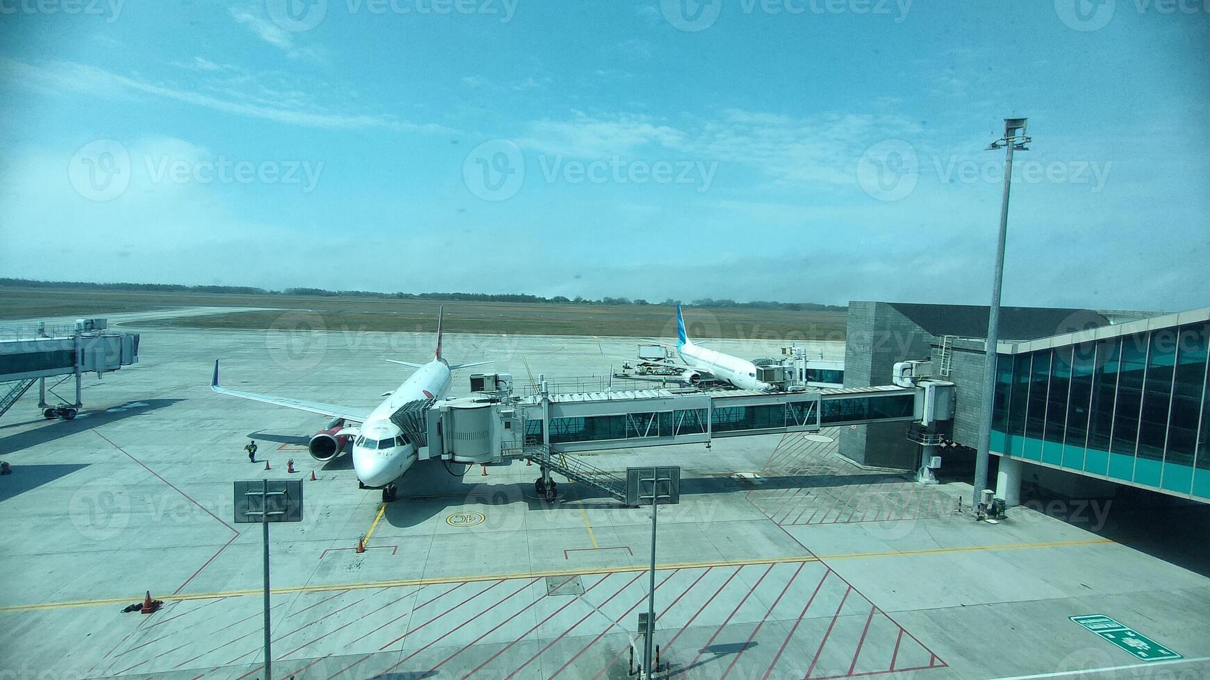 the condition of the airport during the day and there are planes carrying passengers photo