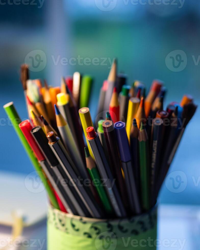 Color pens and pencils in a green container photo