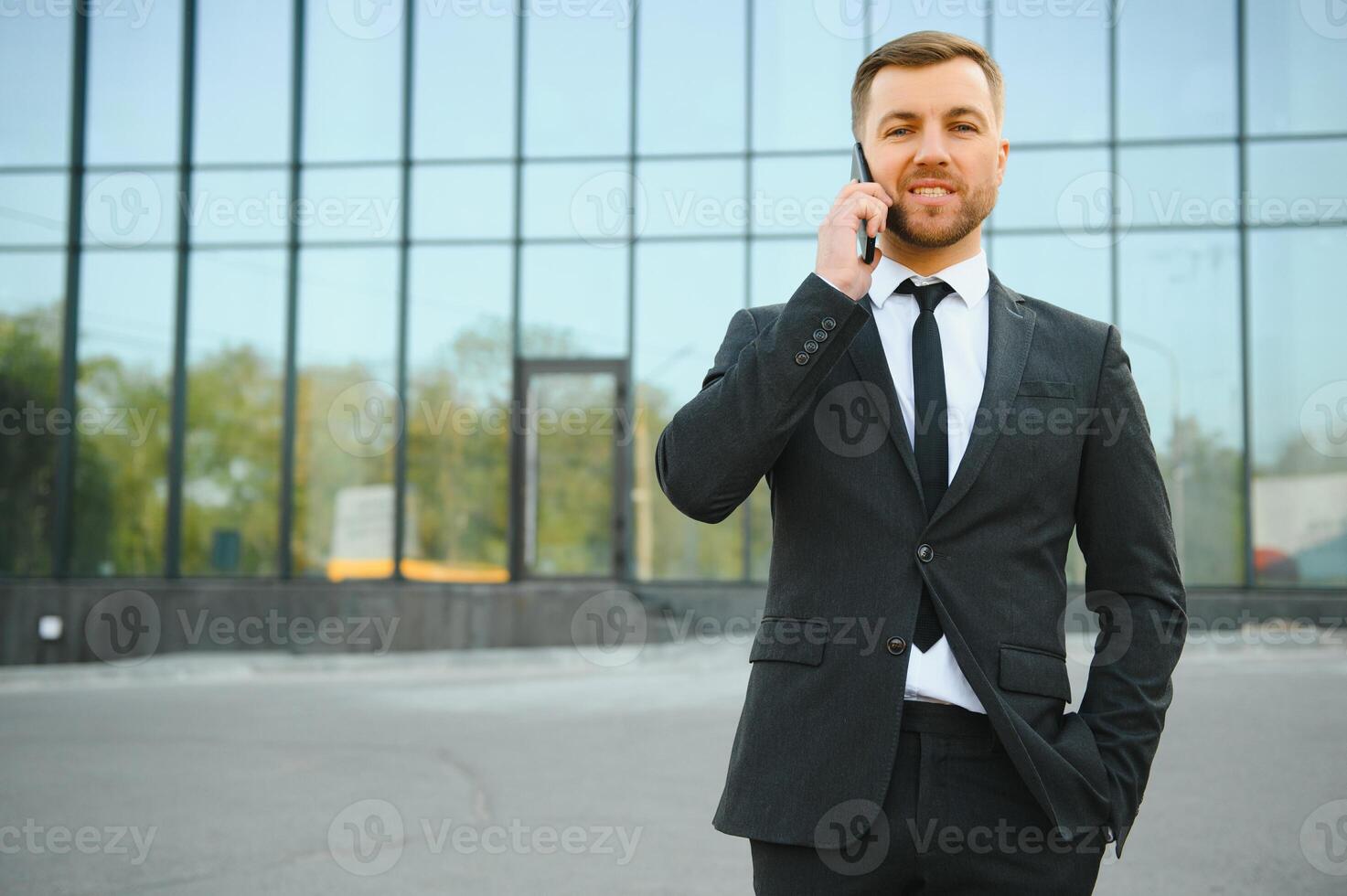 Businessman using smartphone in covered walkway. photo