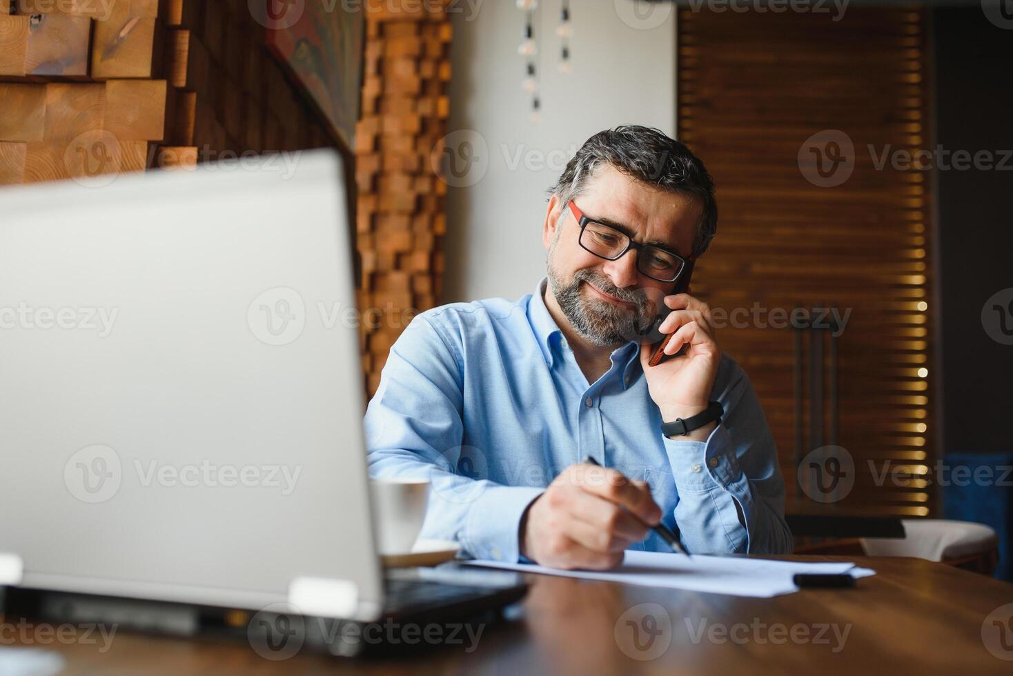 Business, technology and people concept , senior businessman with laptop computer drinking coffee at modern cafe. photo