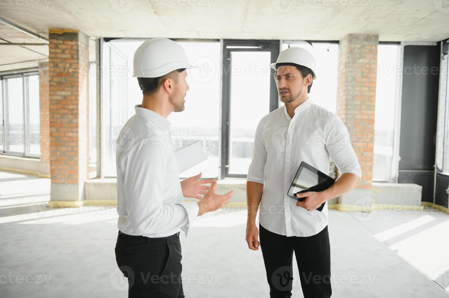 dos especialistas inspeccionar comercial, industrial edificio construcción sitio. real inmuebles proyecto con civil ingeniero foto