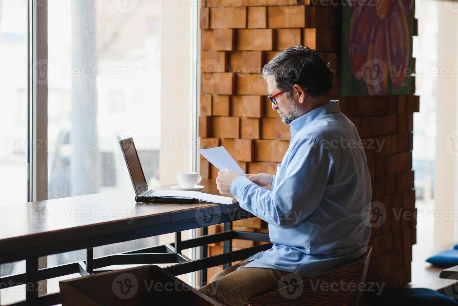 Business, technology and people concept , senior businessman with laptop computer drinking coffee at modern cafe. photo