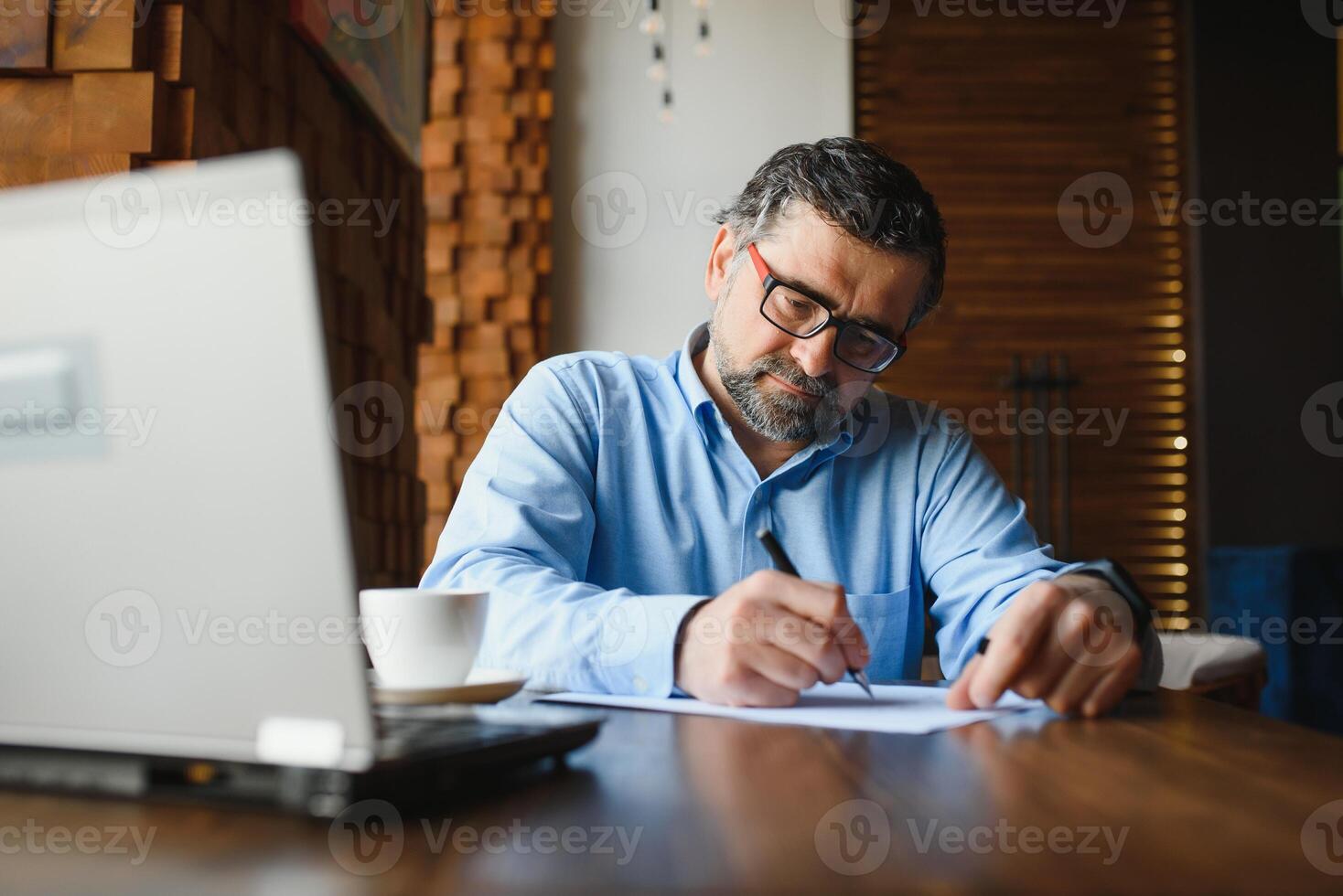 Business, technology and people concept , senior businessman with laptop computer drinking coffee at modern cafe. photo