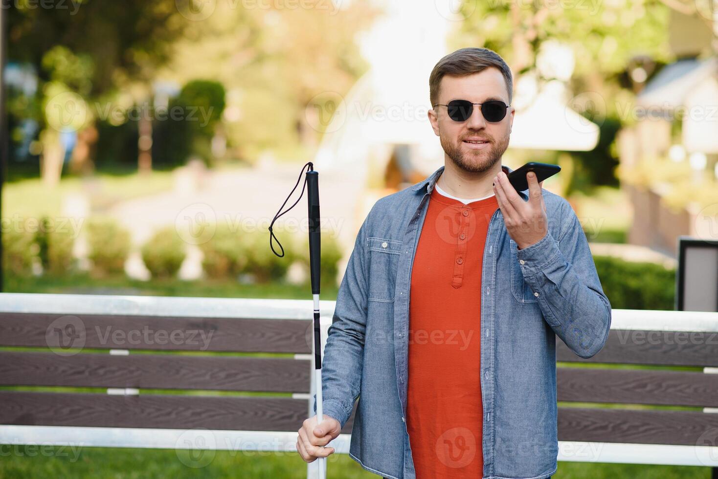 joven cegado hombre utilizando teléfono y enviando voz mensaje foto