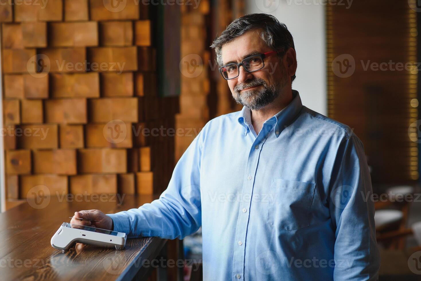 Mature businessman paying with contactless credit card with NFC technology. photo