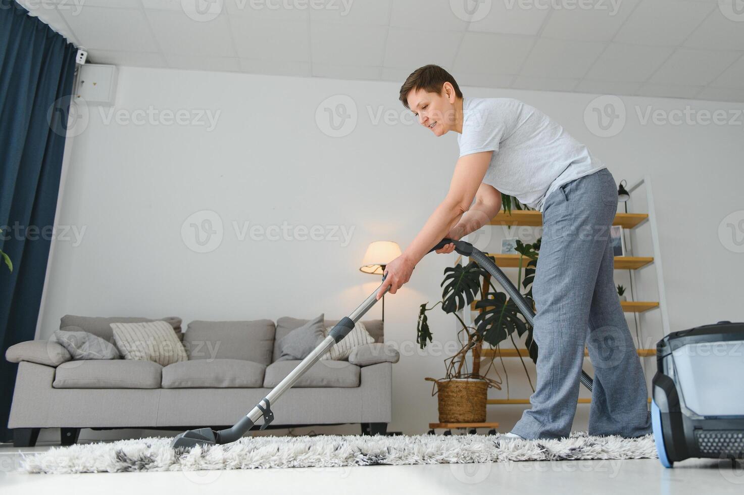 Middle-aged woman cleaning new apartment. photo