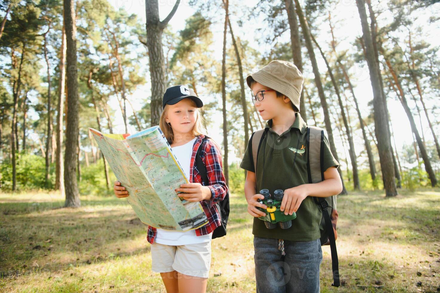 boy and girl go hiking with backpacks on forest road bright sunny day photo