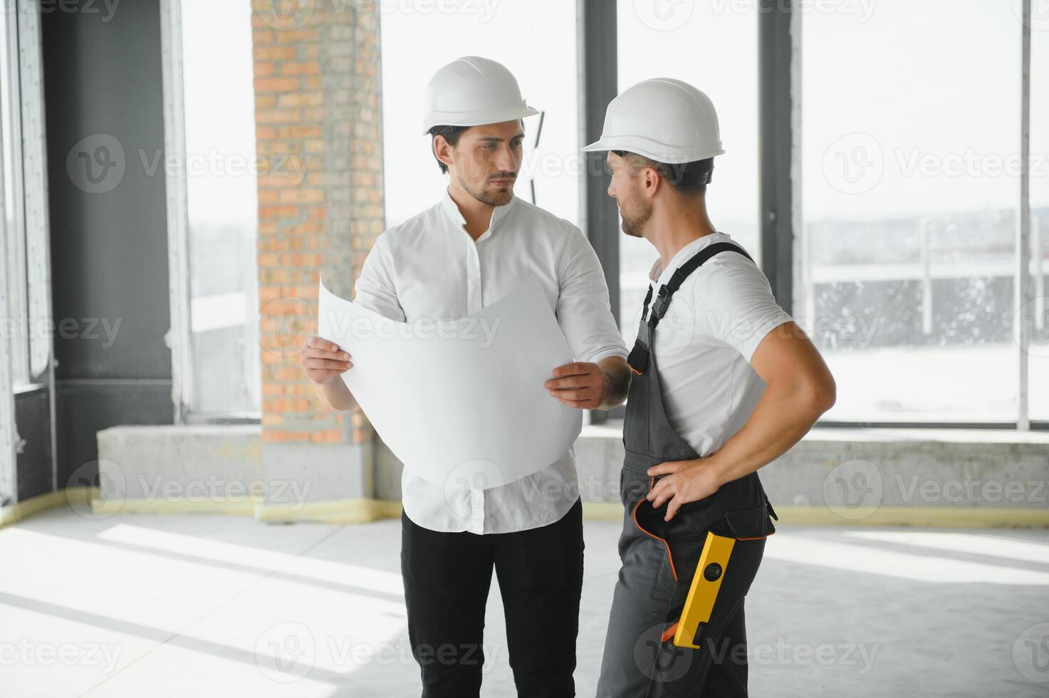 Male Architect Giving Instructions To His Foreman At Construction Site. photo