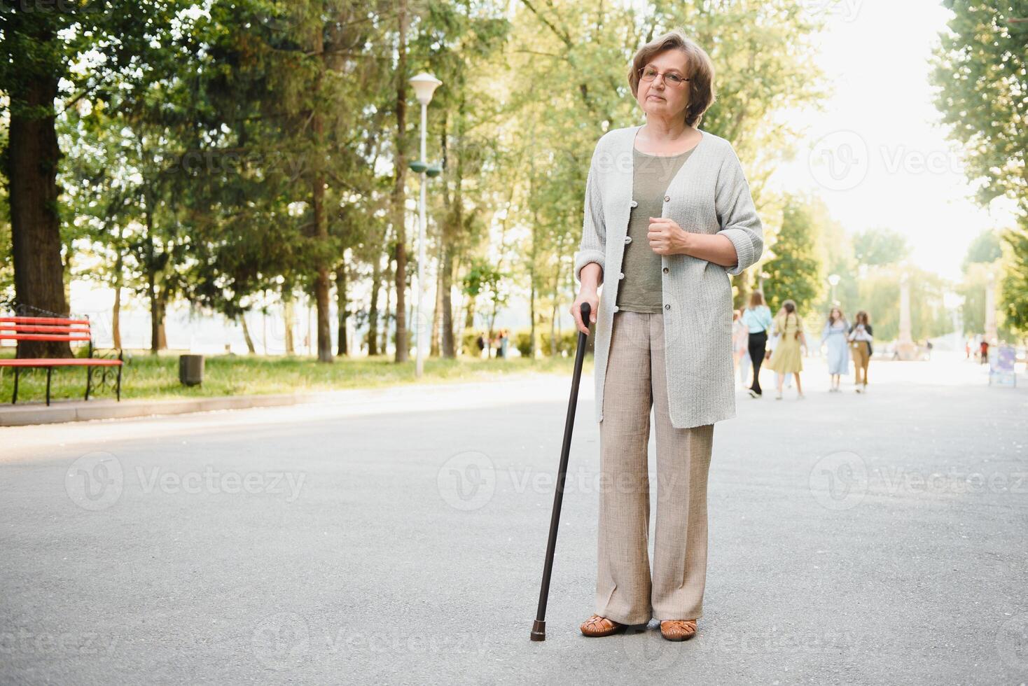 mayor mujer caminando en el parque en verano. foto