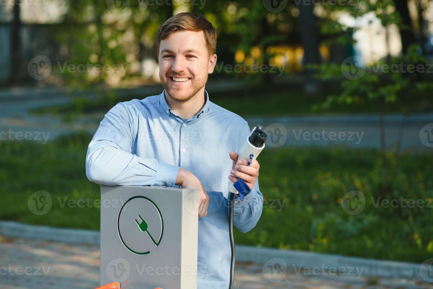 Man Holding Power Charging Cable For Electric Car. photo