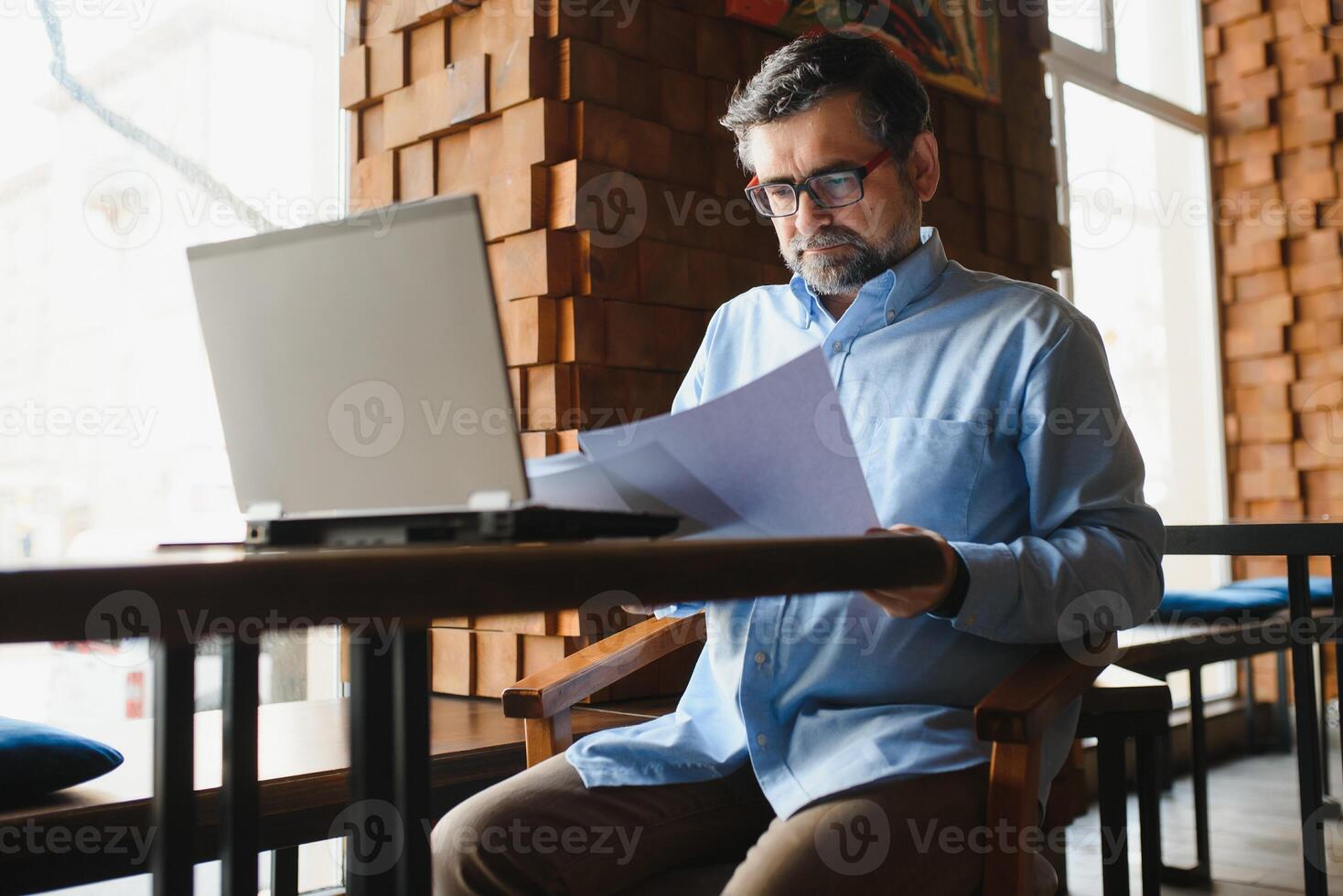 Business, technology and people concept , senior businessman with laptop computer drinking coffee at modern cafe. photo