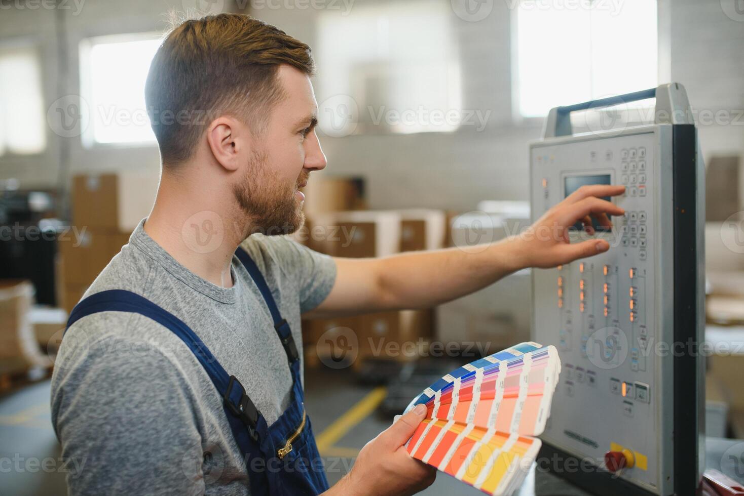 Man working in printing house with paper and paints photo