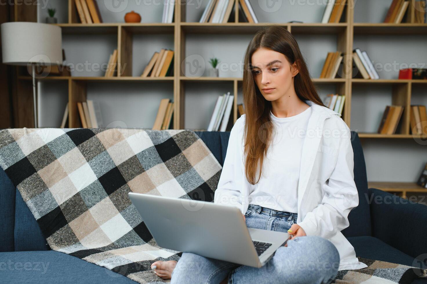 Full length portrait of cheerful charming person sit hold netbook browsing have good mood working home indoors photo