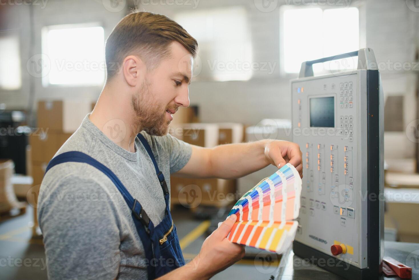 Man working in printing house with paper and paints photo