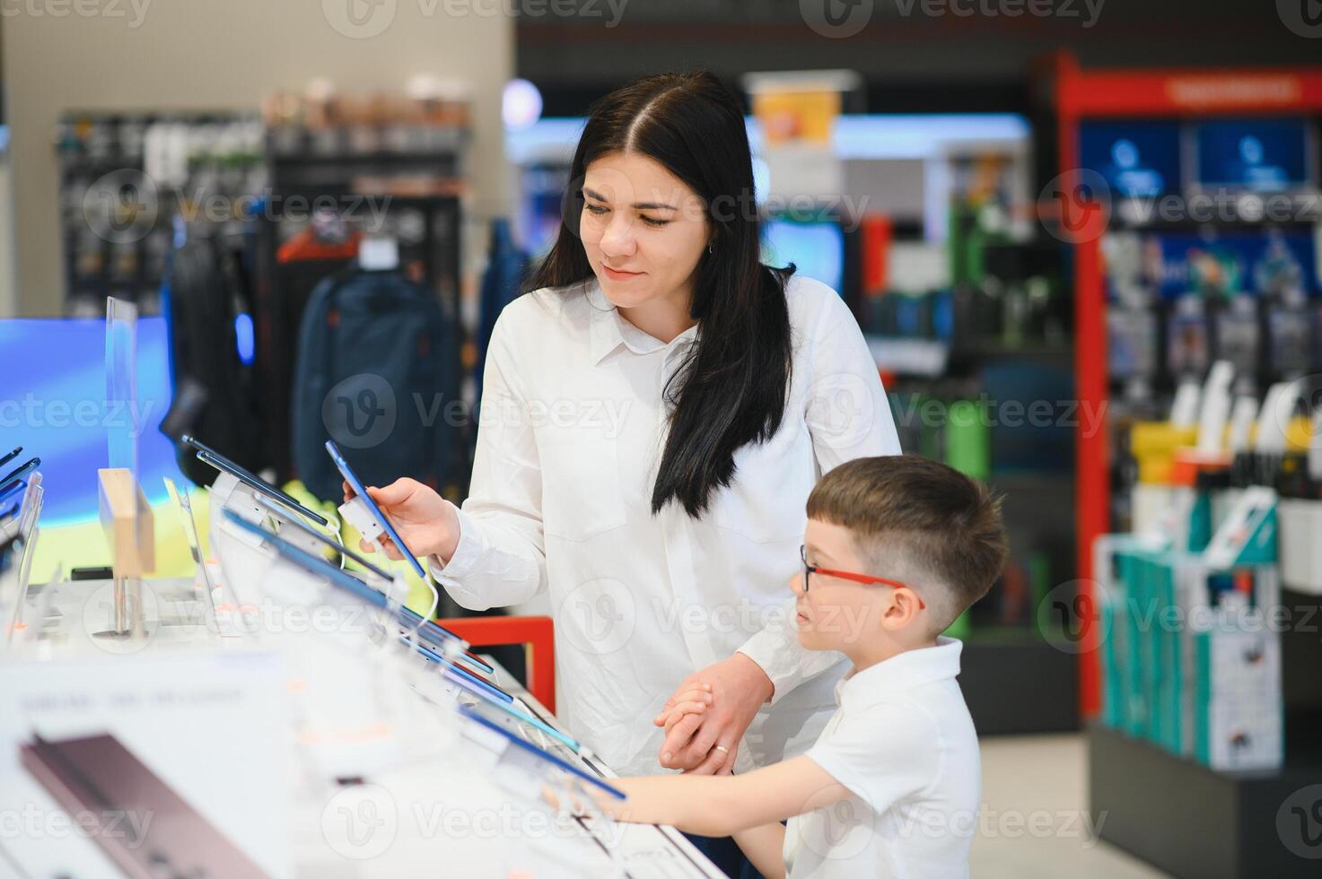 woman with son in store buying new phone. photo