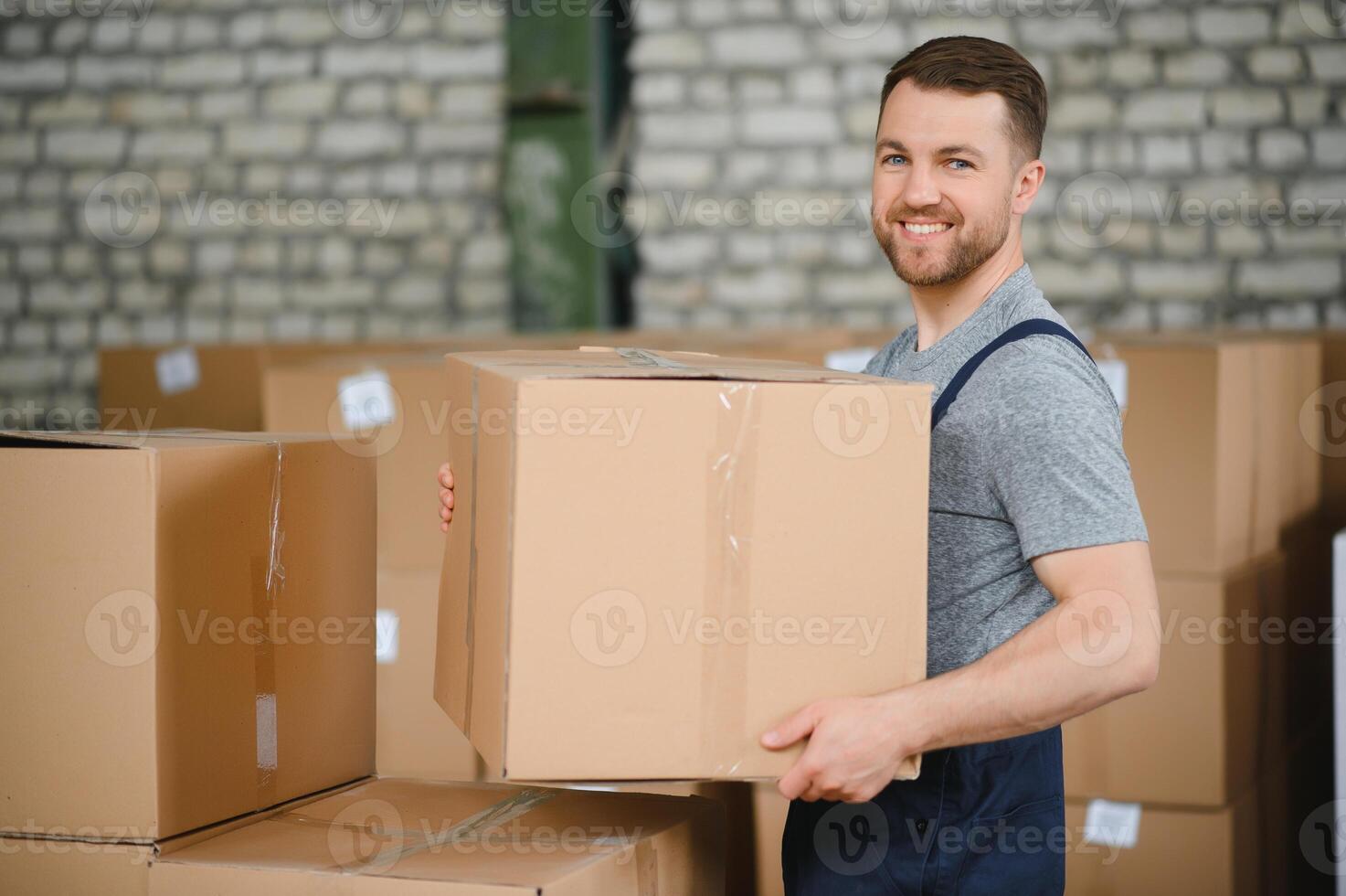 Warehouse worker carrying a carton for delivery to production stock. photo