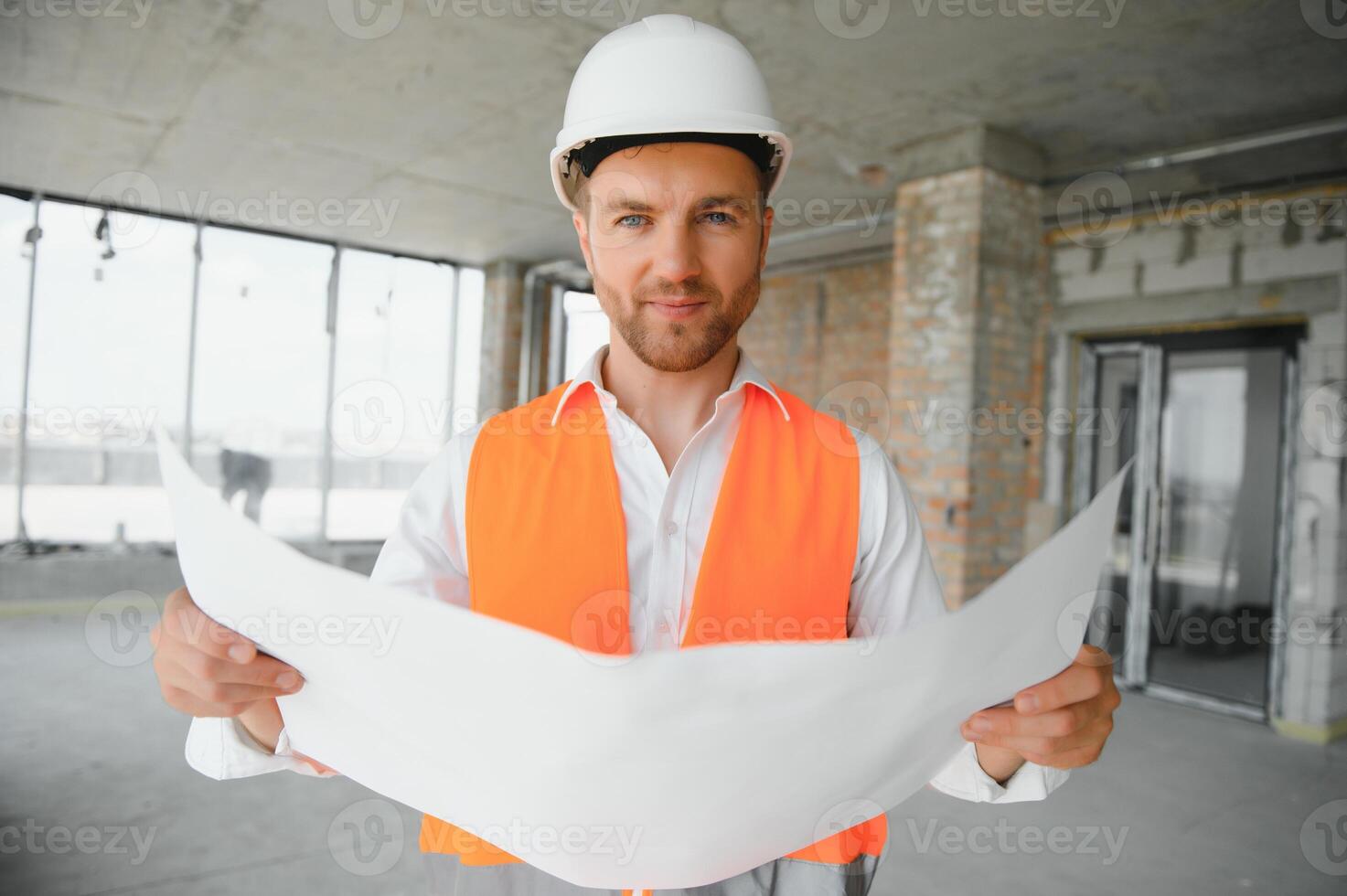 Portrait of man architect at building site. Confident construction manager wearing hardhat. Successful mature civil engineer at construction site with copy space. photo