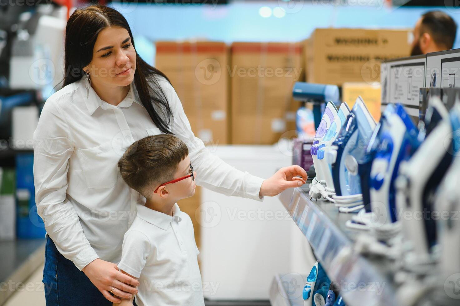 mujer con hijo elegir eléctrico hierro en electrónica Tienda foto