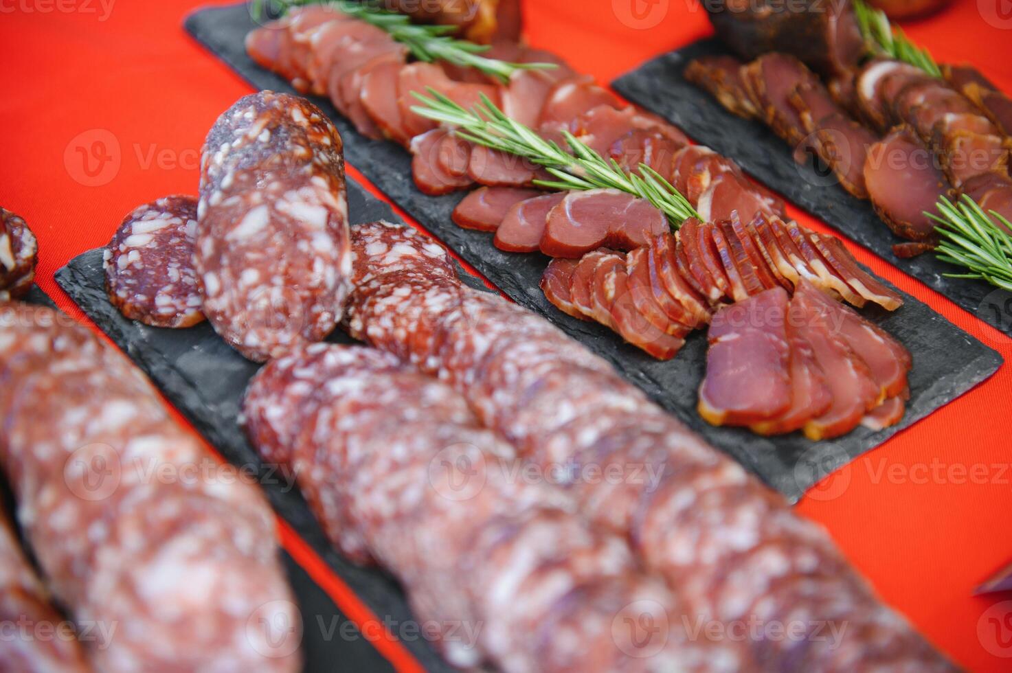 Set of different types of sausages, salami and smoked meat with basil and spices. Top view photo