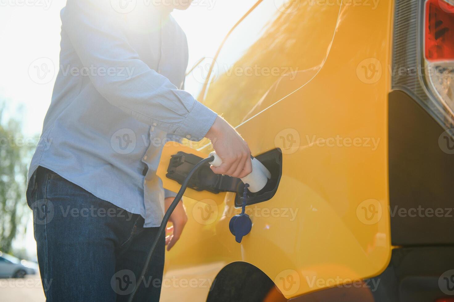 sonriente hombre desenchufar el cargador desde el coche foto