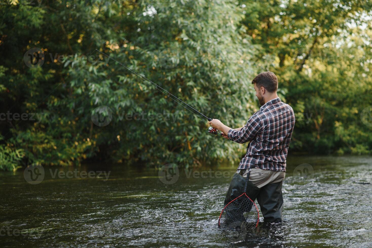 pescador capturas un trucha en el río en verano foto