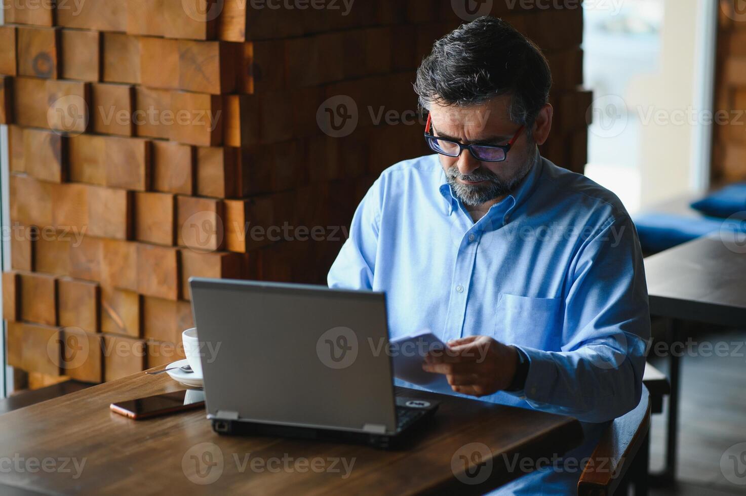 Business, technology and people concept , senior businessman with laptop computer drinking coffee at modern cafe. photo