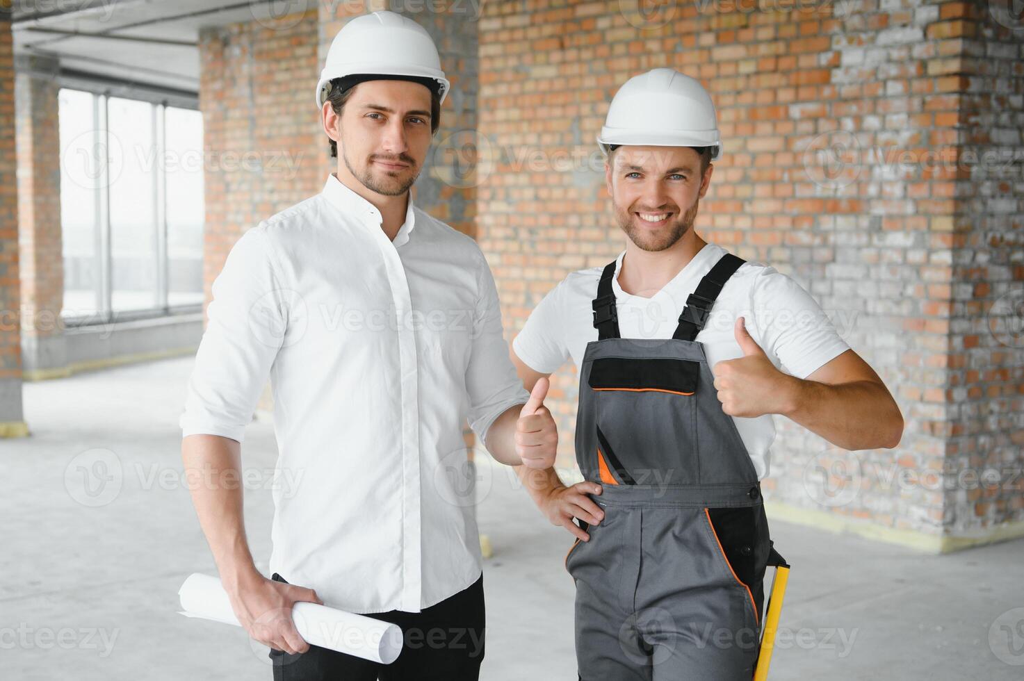 Engineer and worker checking project at building site background, construction site at sunset in evening time photo