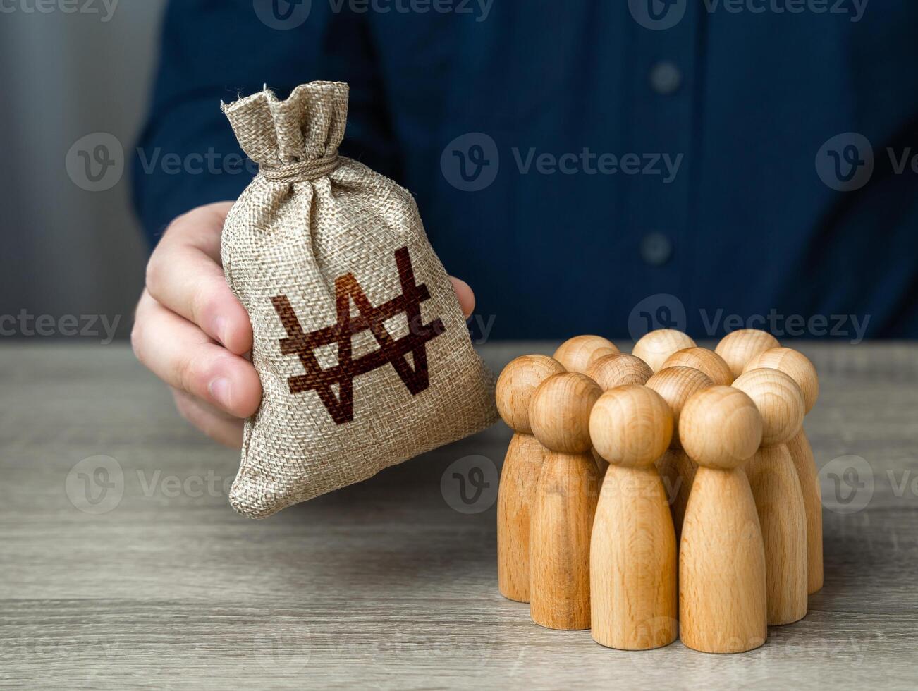 Man adjusts and south korean won money bag to a crowd of people. Financial support. Providing money, paying salaries and grants. Compensation payments. Social assistance to victims of conflict. photo