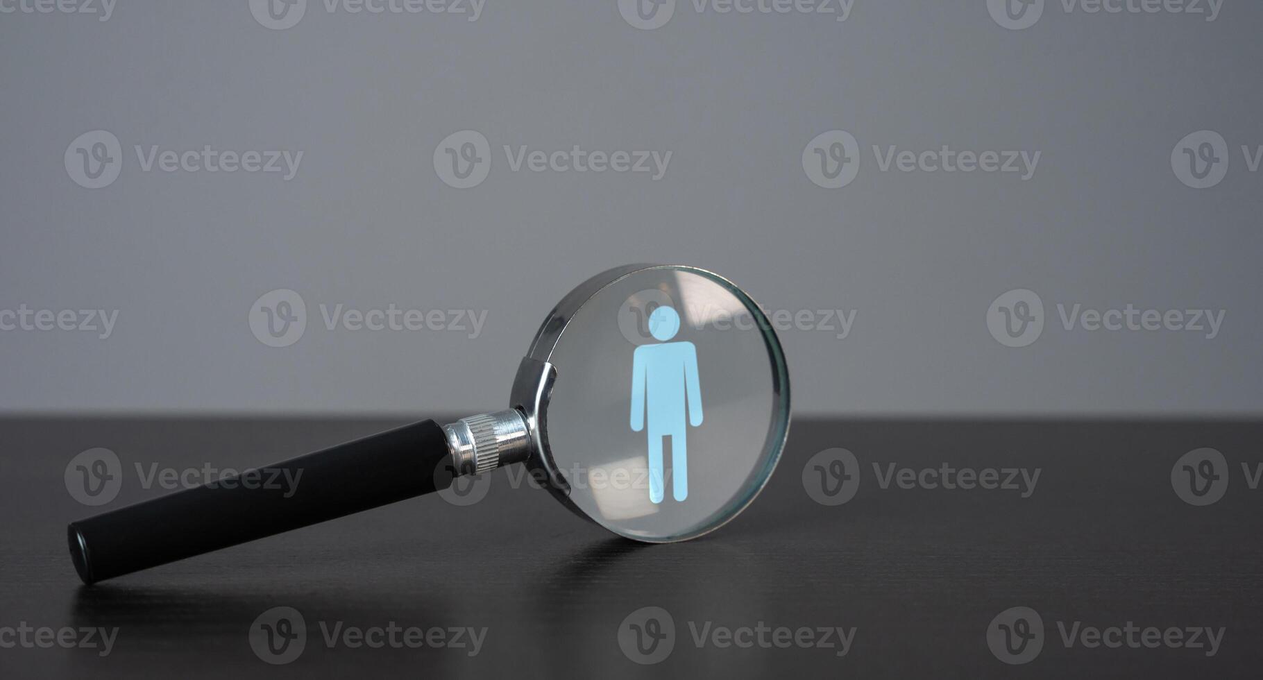 Symbol of a man in a magnifying glass. Finding people for work. Recruitment process, a search for workers to join a team or project. Quest for talent and unique qualities in candidates. photo