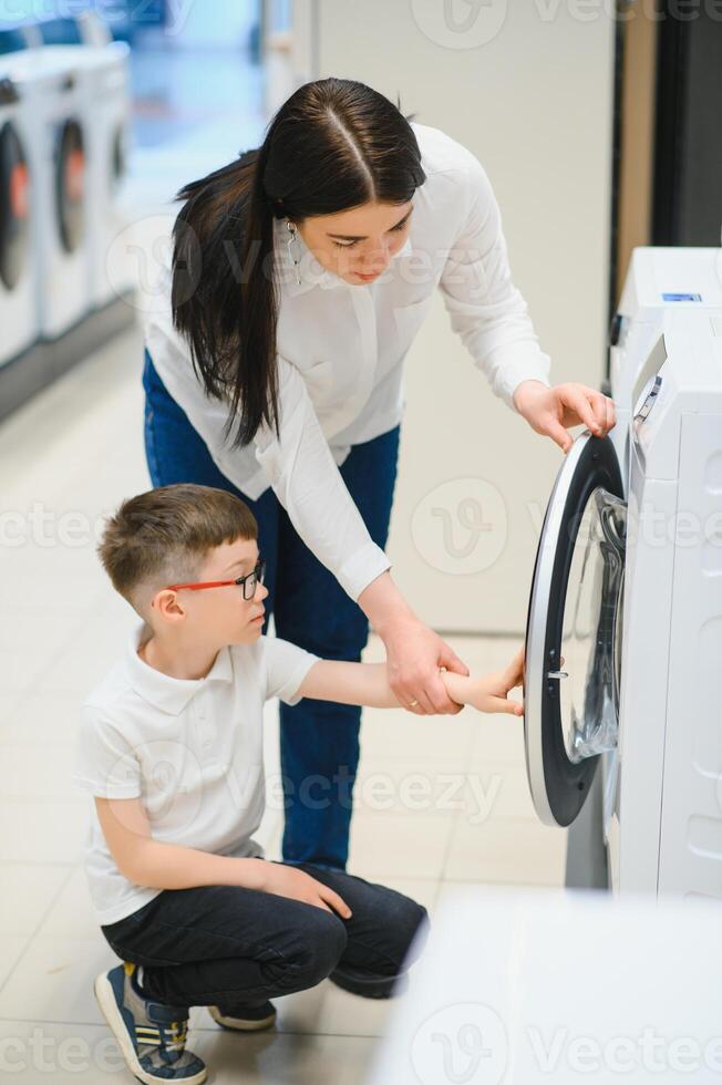 contento familia comprando Lavado máquina en almacenar. foto