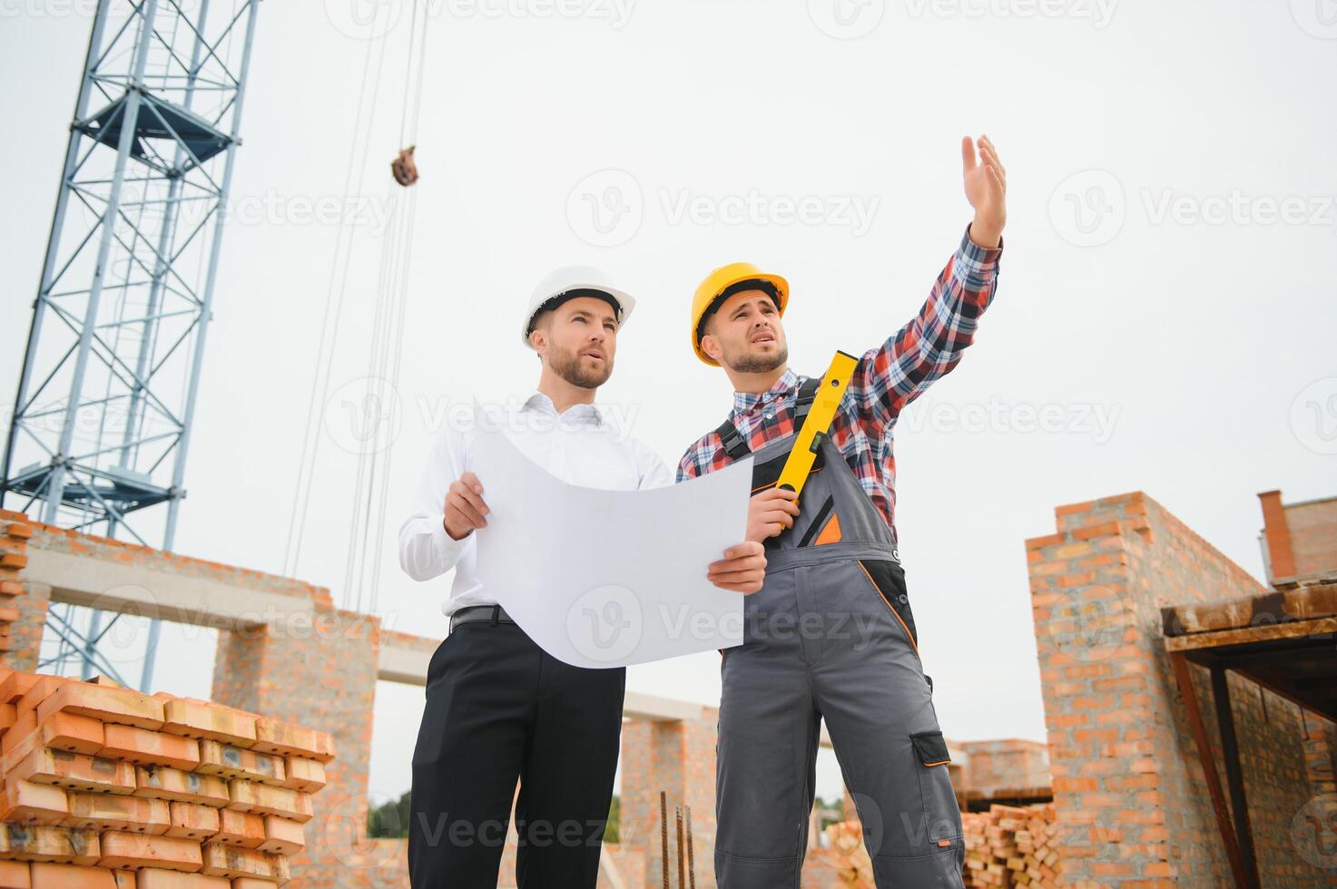 Structural engineer and foreman worker discuss, plan working for the outdoors building construction site photo