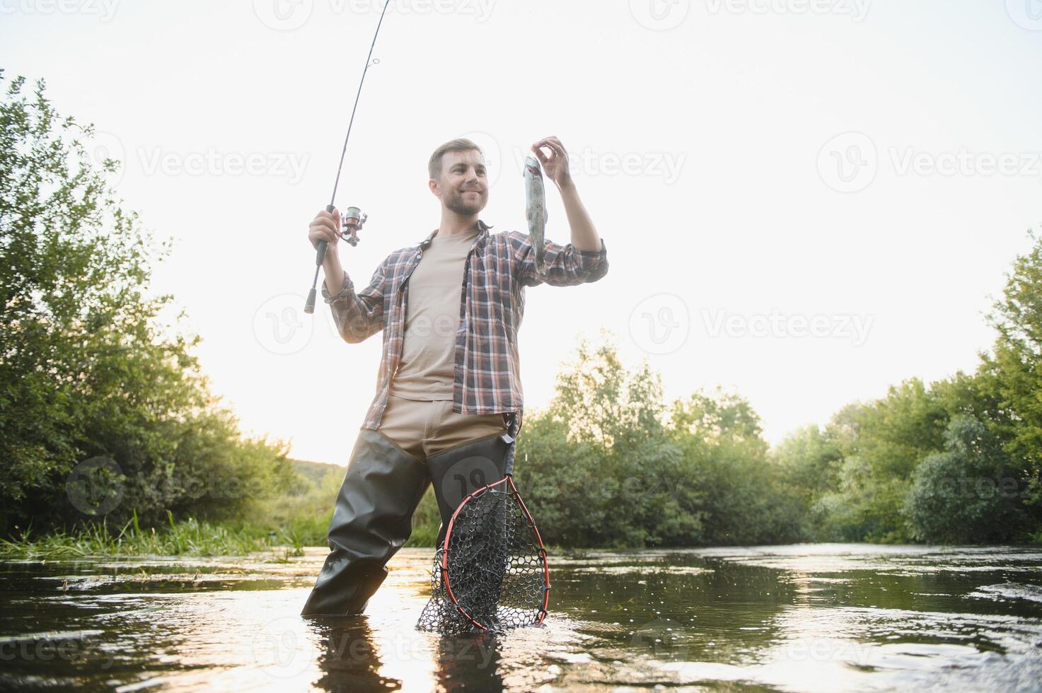 Fisherman hunting trouts in mountain river. Fishing net detail. photo