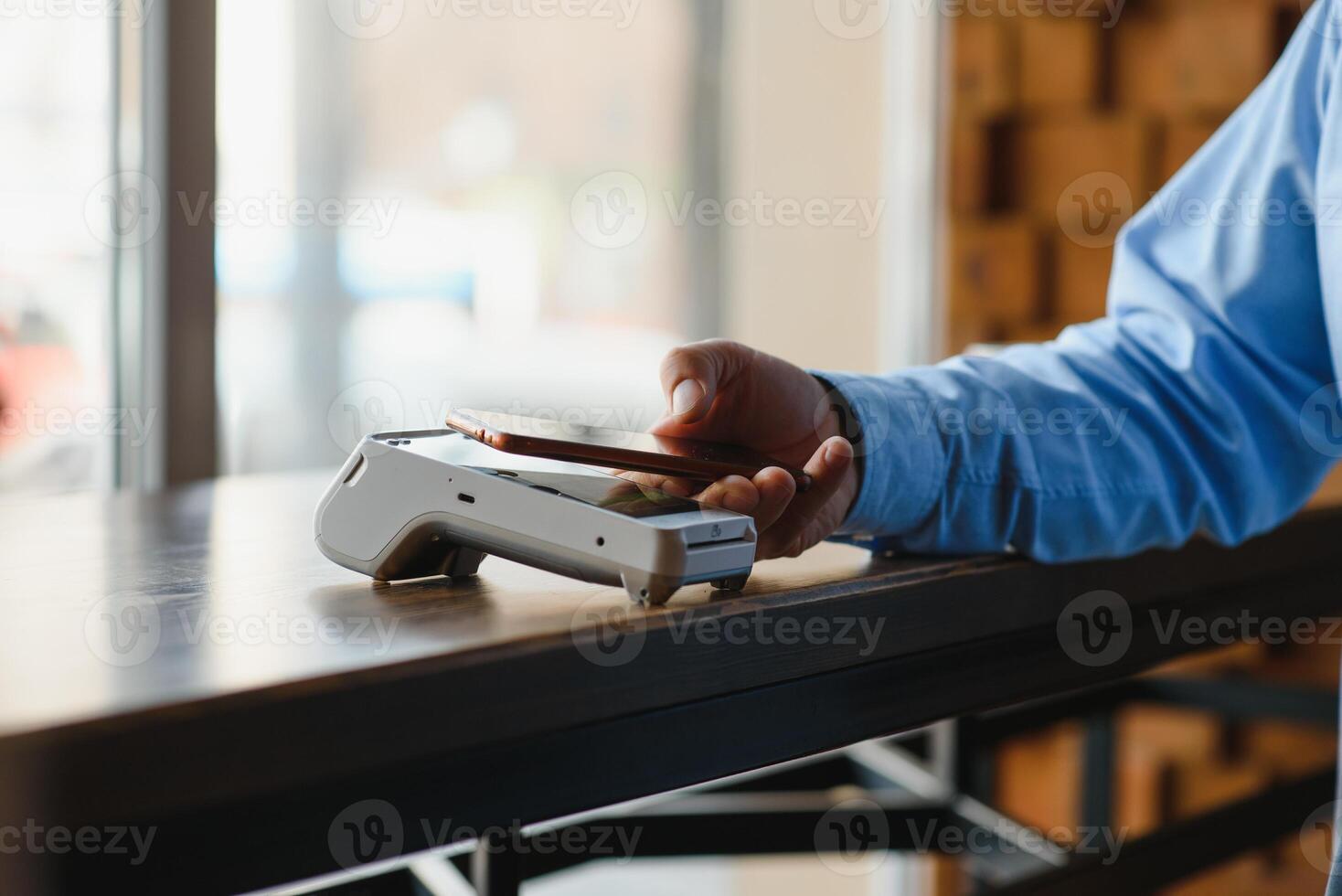 Mature businessman paying with contactless credit card with NFC technology. photo