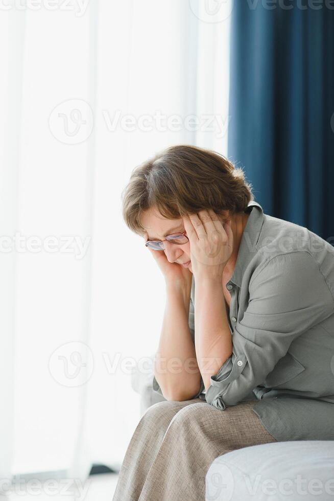 health care, pain, stress, age and people concept - face of senior woman suffering from headache photo